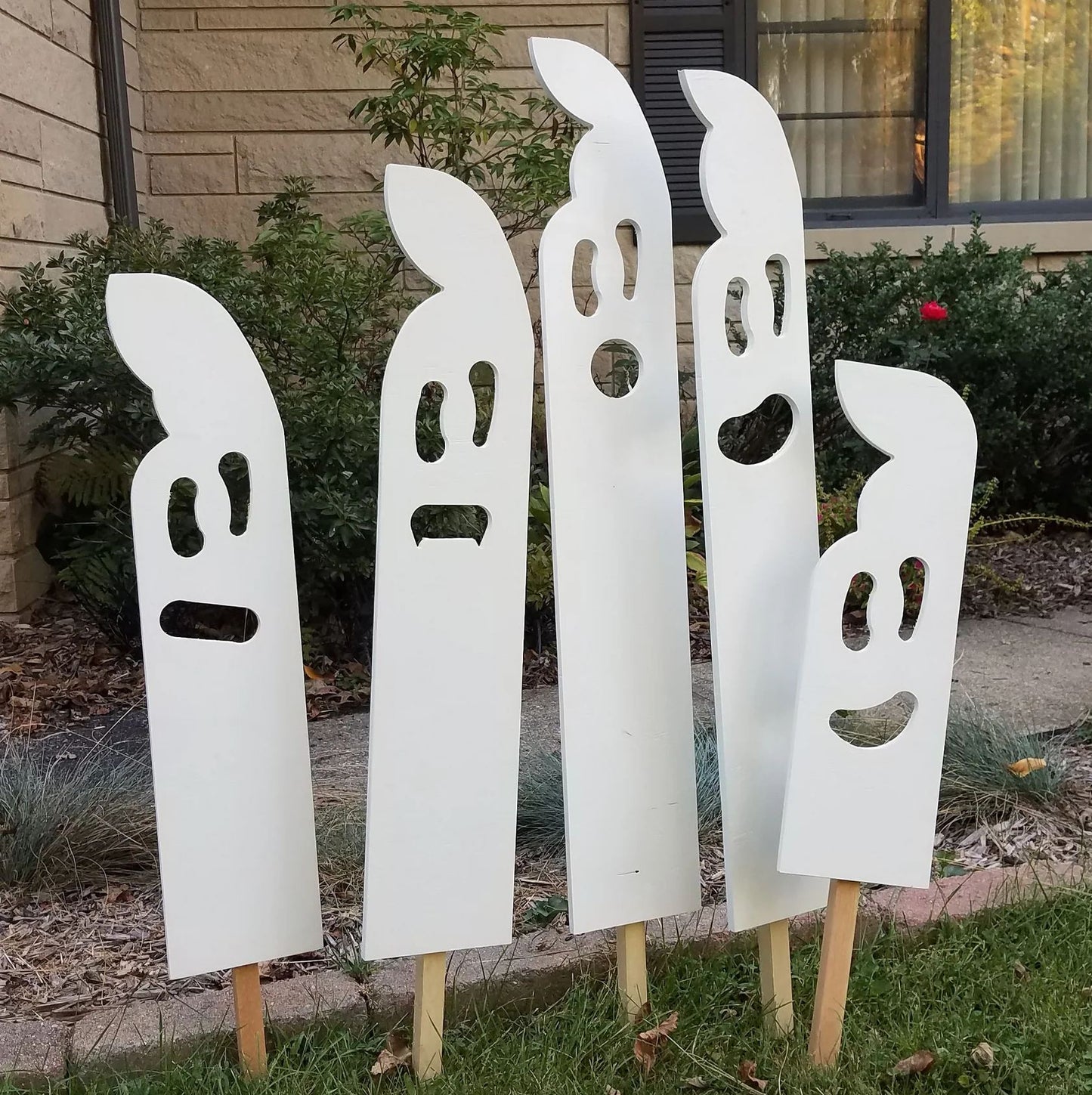 Plywood Halloween ghost yard decorations displayed in a front yard