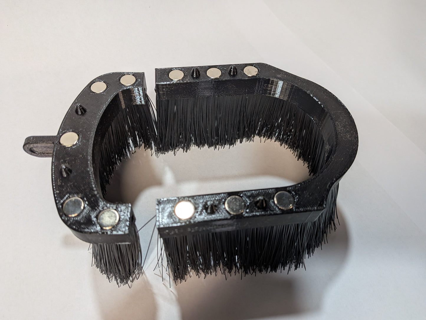 Split brush skirt open showing magnets and anti-dislodge pins