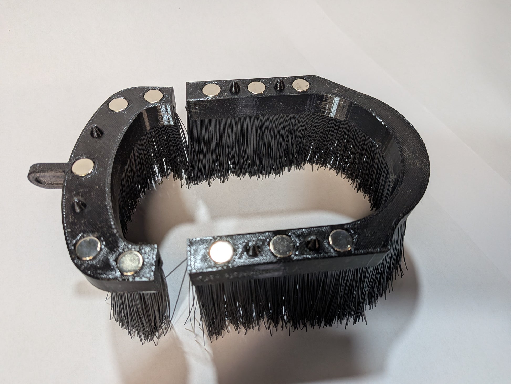 Split brush skirt open showing magnets and anti-dislodge pins