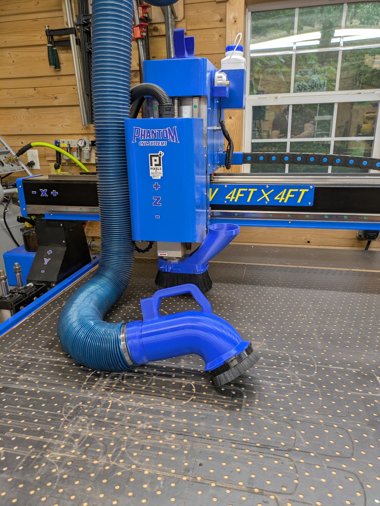 CNC cleaning brush attached to dust hose with quick connect cleaning a CNC spoilboard