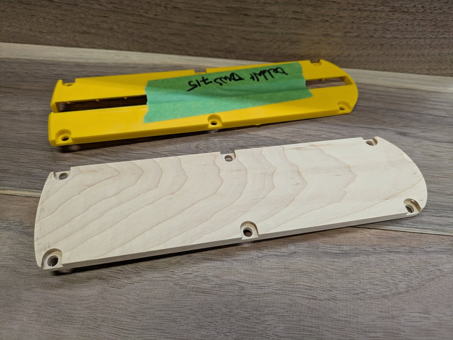 Underside of the DeWalt DWS715 hardwood zero clearance insert next to the factory DeWalt kerf plate