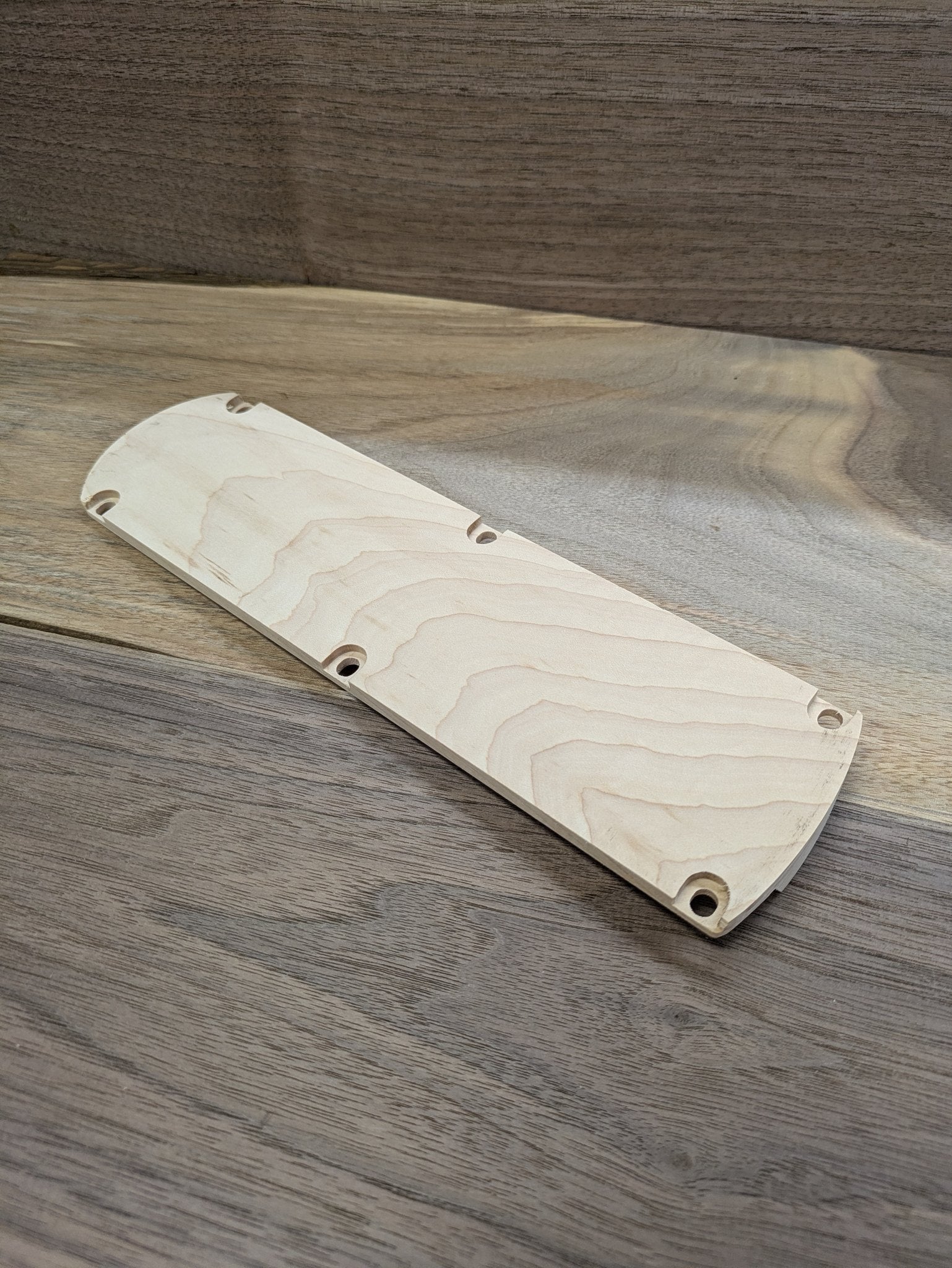 Angled view of the maple DeWalt DWS715 miter saw zero clearance insert on a wood benchtop