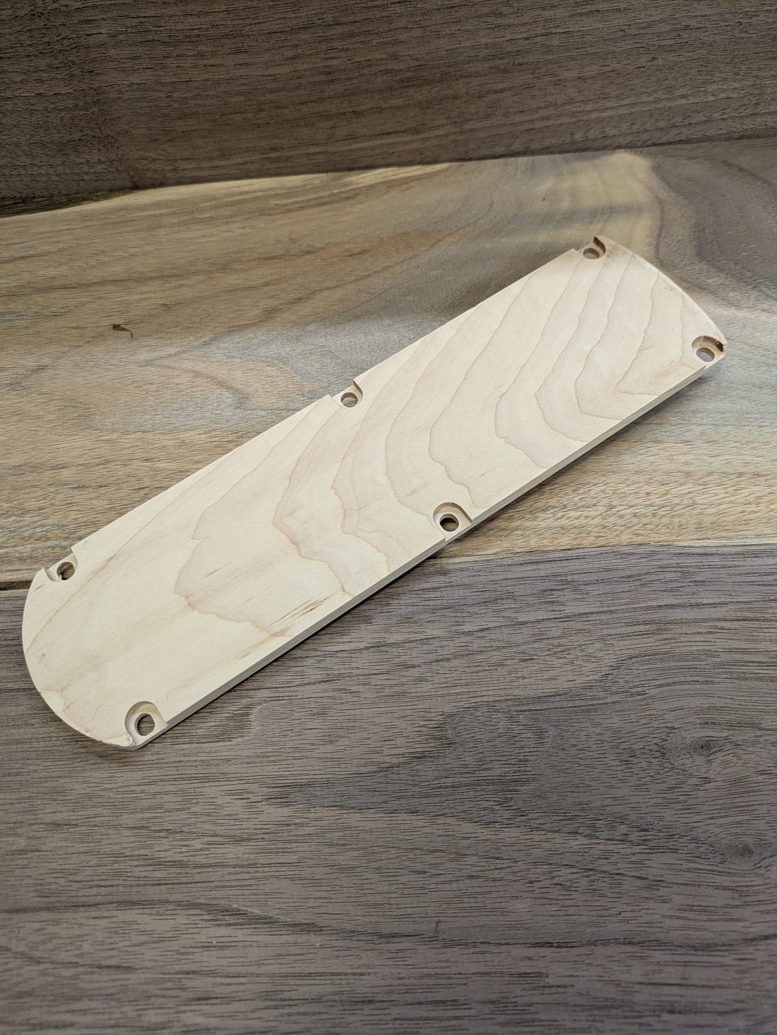 Top view of the DeWalt DWS715 maple zero clearance insert showing countersunk mounting holes